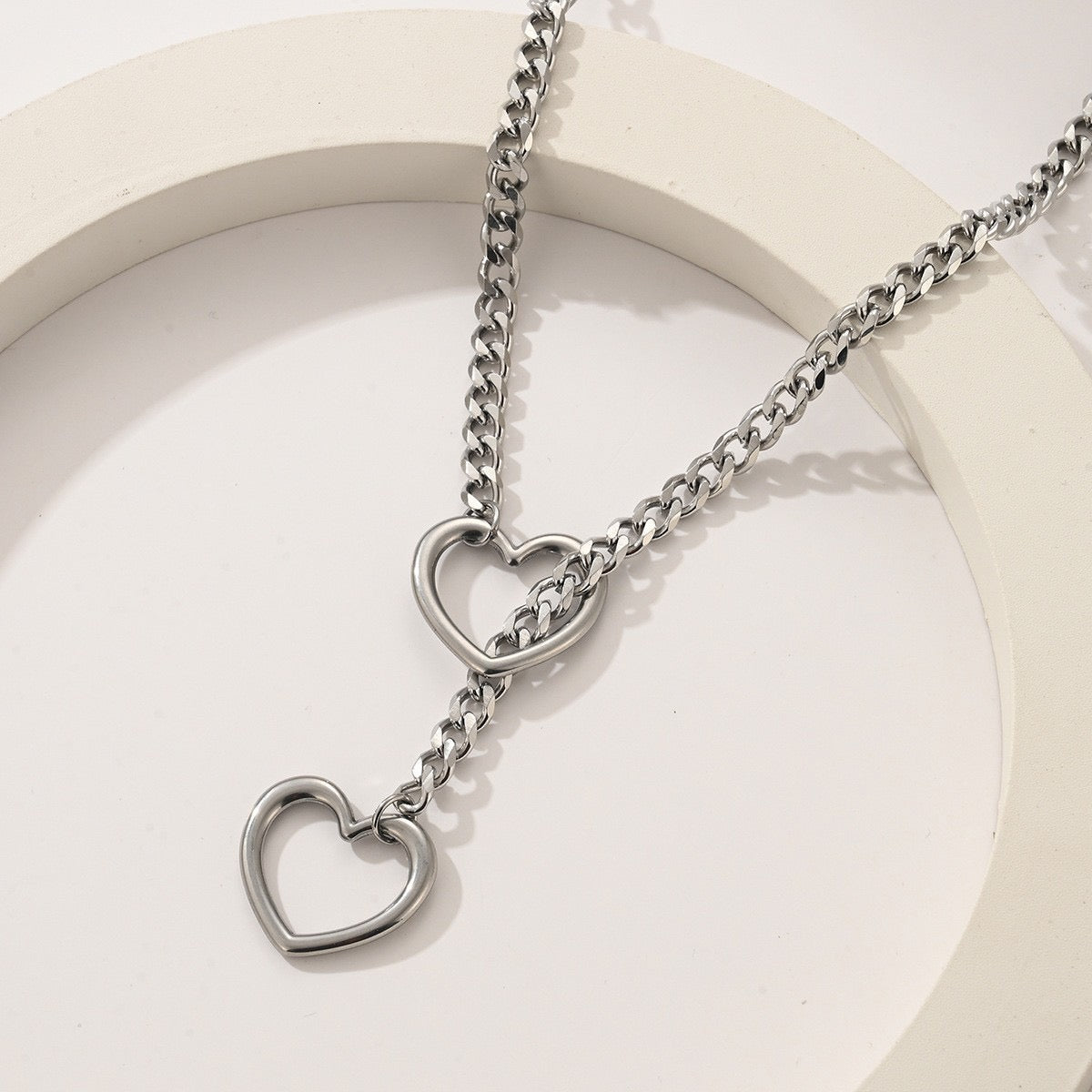 Angled view of stainless steel heart chain choker