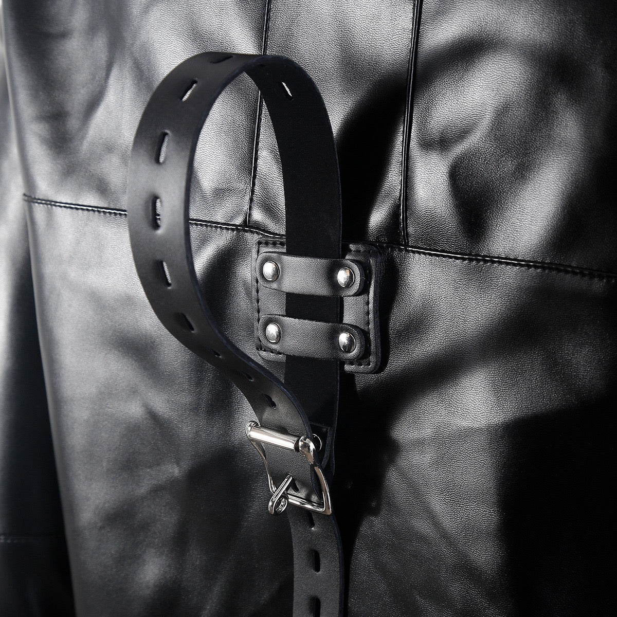 Close-up detail of adjustable back belt on faux leather performance jacket