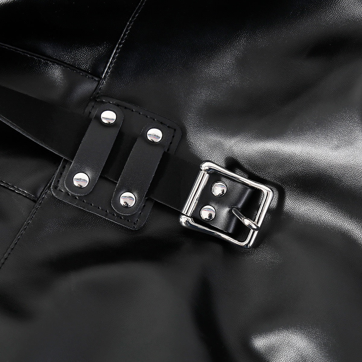 Close-up detail of buckle hardware on faux leather performance jacket