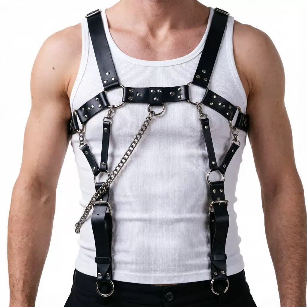 Black faux leather spike detail harness suspender styled over a white tank top