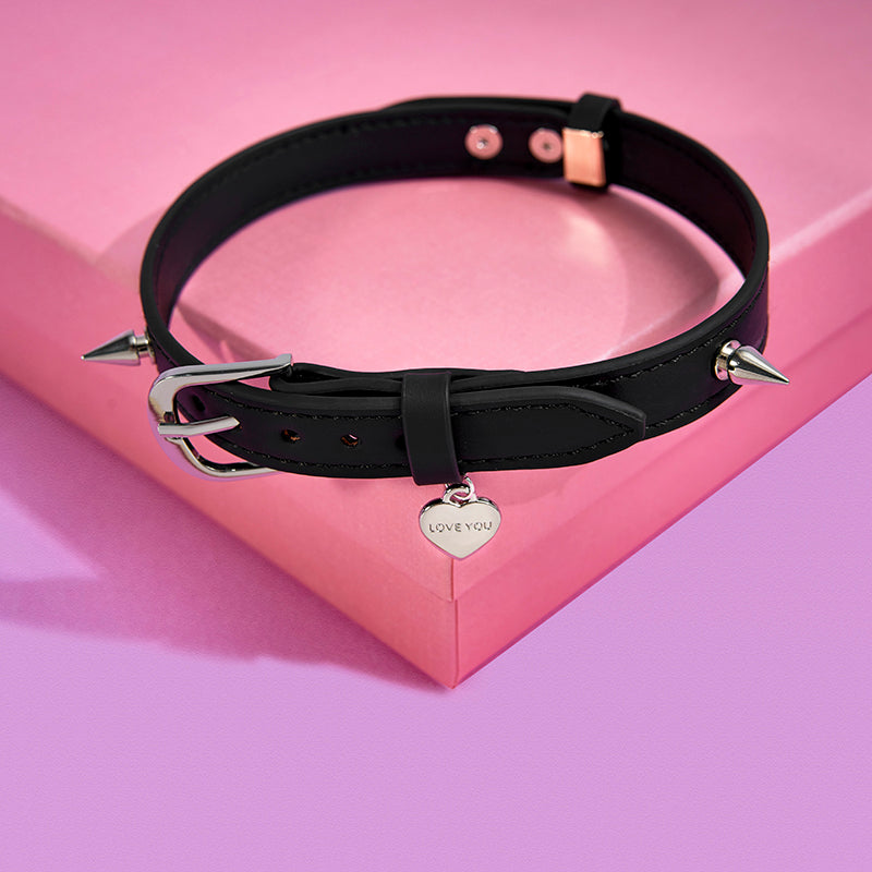 Genuine leather heart charm spike choker displayed on book