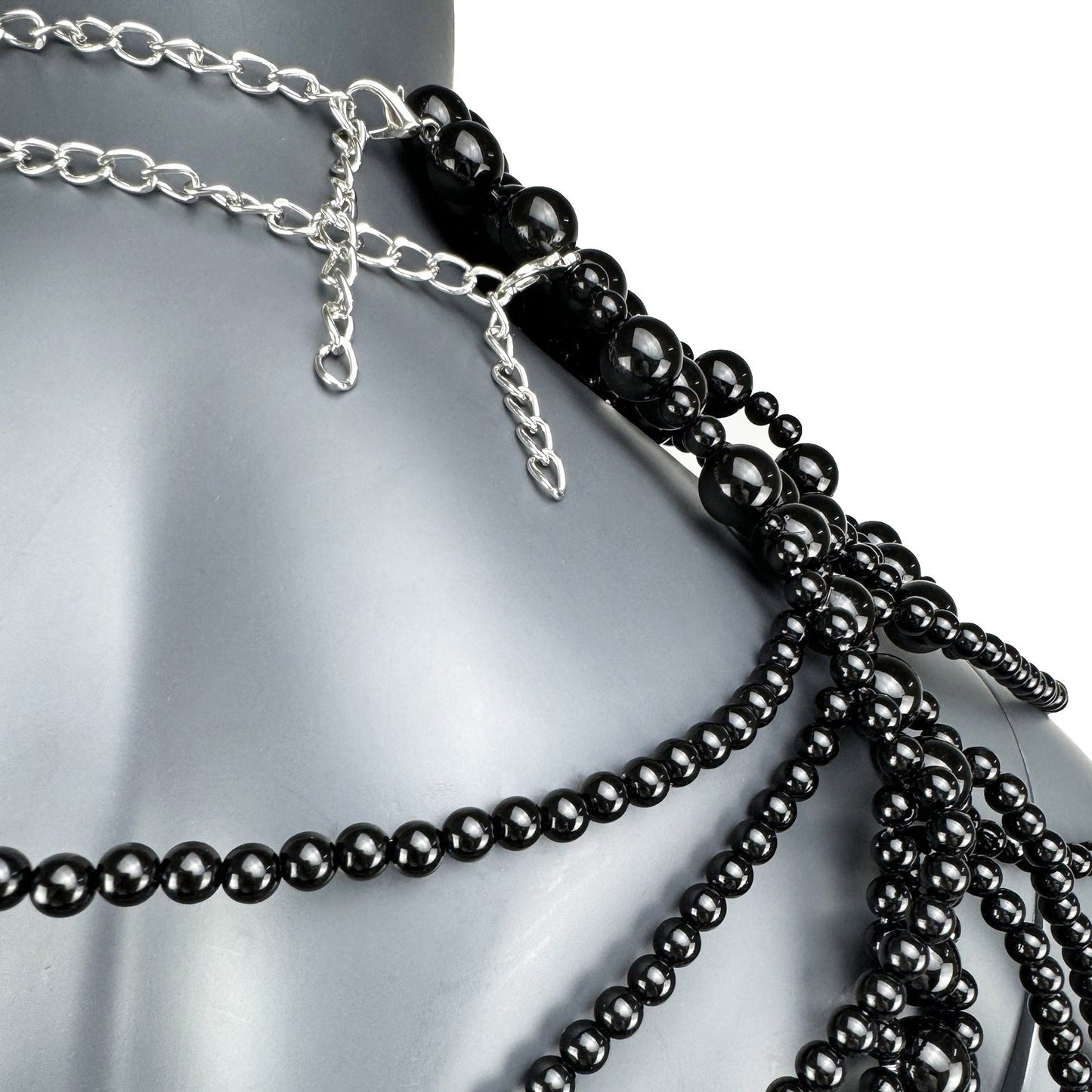 Close-up detail of black pearl strand construction on cape top side
